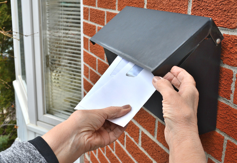 person getting mail from mailbox person getting mail from mailbox